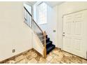 Bright entryway featuring tile flooring, carpeted stairs, and a window allowing natural light, creating a warm and inviting space at 2247 Coronado Pkwy N #D, Denver, CO 80229