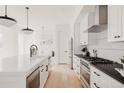 Bright, modern kitchen with white cabinets, a large island and stainless steel appliances at 4139 Benton Street, Denver, CO 80212