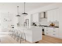 Beautiful kitchen with white cabinetry, large center island, and pendant lighting at 4139 Benton Street, Denver, CO 80212