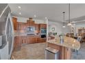 Modern kitchen with stainless steel appliances, wooden cabinets, and granite countertops at 6839 Estes Dr, Arvada, CO 80004