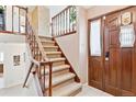 Inviting entryway featuring a staircase with wooden banister and a solid wood front door at 3298 Quail St, Wheat Ridge, CO 80033