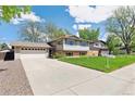 Charming exterior of a two-story home with a long driveway and well-manicured lawn at 3298 Quail St, Wheat Ridge, CO 80033