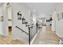 Inviting entryway with light wood floors and modern railing leading to a spacious living area at 1195 Melting Snow Way, Castle Rock, CO 80109