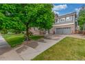 Two-story home with brick and siding exterior, complemented by a mature shade tree at 11716 Fairplay St, Commerce City, CO 80603
