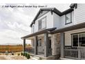 Charming two-story home featuring a welcoming front porch with stone accents and elegant gray trim at 5099 S Robb St, Littleton, CO 80127