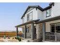 Stylish two-story home with charming brick accents and a welcoming covered front porch at 5099 S Robb St, Littleton, CO 80127
