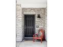 Inviting front entry with a dark-colored door framed by stone and a cute chair offering a warm welcome at 5099 S Robb St, Littleton, CO 80127