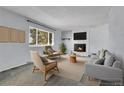 Cozy living room featuring a fireplace, comfortable seating, natural lighting, and minimalist decor at 6250 S Windermere St, Littleton, CO 80120