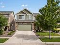 Two-story home featuring stone accents, an attached two-car garage, and professionally landscaped front yard during the daytime at 5358 Ventura St, Denver, CO 80249
