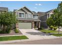 Exterior of a two-story home with stone accents, a two-car garage, and professionally landscaped yard in daylight at 5358 Ventura St, Denver, CO 80249