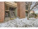 Well-lit staircase leading to upper level, featuring brick accents and iron railings, providing easy access to units at 4899 S Dudley St # 17G, Littleton, CO 80123