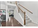 Bright foyer featuring hardwood floors, a staircase with white railing, and views into the living area at 20529 E Brunswick Pl, Aurora, CO 80013
