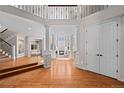 Grand foyer featuring hardwood floors, elegant columns, an open staircase, and a view to the great room at 2230 E Grand Ave, Cherry Hills Village, CO 80113