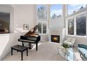 Bright and airy living room with a soaring ceiling, a fireplace, a piano, and large windows at 2230 E Grand Ave, Cherry Hills Village, CO 80113