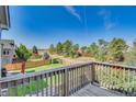 Expansive backyard view from the deck with a lush green lawn and mature trees at 9905 Aftonwood St, Highlands Ranch, CO 80126