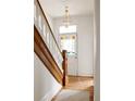 Inviting entryway with hardwood floors, decorative staircase, and colorful stained-glass door, creating a warm welcome at 2808 N Humboldt St, Denver, CO 80205