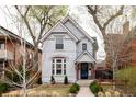 Charming two-story home featuring a painted brick facade, landscaped yard, and eye-catching trim details at 2808 N Humboldt St, Denver, CO 80205
