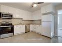 Well-equipped kitchen with stainless steel appliances, white cabinets, and tiled flooring at 731 Uvalda St, Aurora, CO 80011