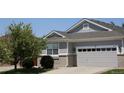 A well-maintained home with a grey exterior, brick accents, a two-car garage and a new roof at 16351 E 104Th Pl, Commerce City, CO 80022