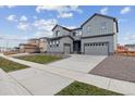 Two-story house with gray siding, landscaped lawn, and a two-car garage at 1750 Marlowe W Cir, Erie, CO 80516