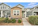 Charming two-story townhome with a stone facade, well-maintained landscaping, and a welcoming front entrance at 14284 W 88Th Dr # B, Arvada, CO 80005