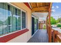 Enclosed sunroom highlighting natural light, a wooden deck, and brick accents at 2196 W 56Th Ave, Denver, CO 80221
