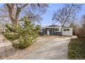 Inviting single-story home with gray siding, a manicured yard, and a concrete driveway at 2424 S Humboldt St, Denver, CO 80210