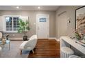 Bright living room with hardwood floors, a front door with glass, and a large window with shutters at 285 E Dartmouth Ave, Englewood, CO 80113