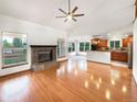 Bright living room with a stone fireplace, hardwood floors, and seamless access to the kitchen at 584 W Prestwick Way, Castle Rock, CO 80104