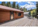 Expansive wooden deck perfect for entertaining, with views of the surrounding trees at 11080 S Deer Creek Rd, Littleton, CO 80127