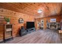 Cozy living room with wood-paneled walls, fireplace, and modern entertainment setup at 11080 S Deer Creek Rd, Littleton, CO 80127