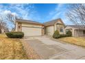 Charming exterior with tan siding, stone accents, well maintained lawn, and a two-car garage at 9693 W Euclid Dr, Littleton, CO 80123