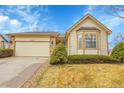 Charming exterior with tan siding, stone accents, well maintained lawn, and a two-car garage at 9693 W Euclid Dr, Littleton, CO 80123