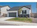 Modern Ranch home with gray garage and landscaped yard at 27728 E 10Th Dr, Aurora, CO 80018