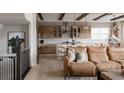 Open-concept kitchen features an island with seating, wood cabinets, and stainless steel appliances, flowing into the living space at 27608 E Ottawa Ave, Aurora, CO 80016