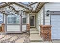 Home's front door featuring stone detailing, front storm door, and a bay window at 815 Concho Ct, Castle Rock, CO 80104