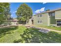 View of the green townhome from the lawn, showcasing its inviting curb appeal at 940 S Peoria St, Aurora, CO 80012