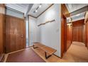 Bright foyer showcasing a modern bench, coat rack, natural light, and wood floors throughout the entry way at 4920 E Vassar Ln, Denver, CO 80222