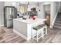 Bright kitchen with white cabinetry, an island with seating, and updated flooring at 8653 W 67Th Ave, Arvada, CO 80004