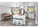 Open concept kitchen with island seating, stainless steel appliances, and wood dining table at 8653 W 67Th Ave, Arvada, CO 80004