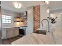 Bright kitchen with stainless appliances, marble countertop, brick accent wall at 4441 Elm Ct, Denver, CO 80211