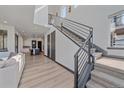 Bright entryway with staircase, modern railing, hardwood floors, and open layout at 6047 N Nepal Ct, Aurora, CO 80019