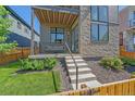 Charming front entrance with concrete steps, stone veneer, and manicured landscaping at 6047 N Nepal Ct, Aurora, CO 80019