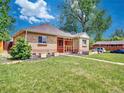 Quaint single-story brick home featuring well-maintained front lawn and cozy screened-in porch at 1600 Xanthia St, Denver, CO 80220