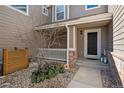 Inviting covered front porch with rock landscaping and decorative accents at 7700 W Grant Ranch Blvd # 7C, Littleton, CO 80123