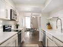 Open concept kitchen with stainless steel appliances and white cabinets at 99 S Downing St # B2, Denver, CO 80209