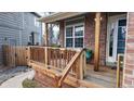 Inviting front porch with wooden railings, brick accents, and a cozy seating area at 12861 Royal Ct, Broomfield, CO 80020