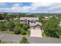 Stunning aerial view of home, surrounded by mature trees, nestled in a picturesque neighborhood with mountain views at 6299 Ellingwood Point Pl, Castle Rock, CO 80108