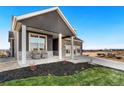Inviting front porch with seating area, stone accents, and well-maintained landscaping at 359 Josef Cir, Fort Lupton, CO 80621