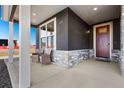 Cozy front porch with seating area, stone accents, and a view of the neighborhood at 359 Josef Cir, Fort Lupton, CO 80621